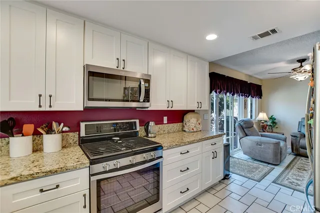 a kitchen with granite countertop cabinets stainless steel appliances and wooden floor