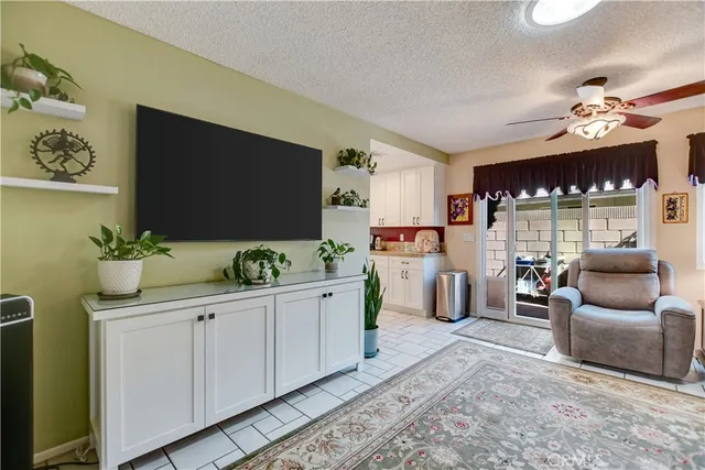 a hall way with furniture a flat screen tv and a potted plant