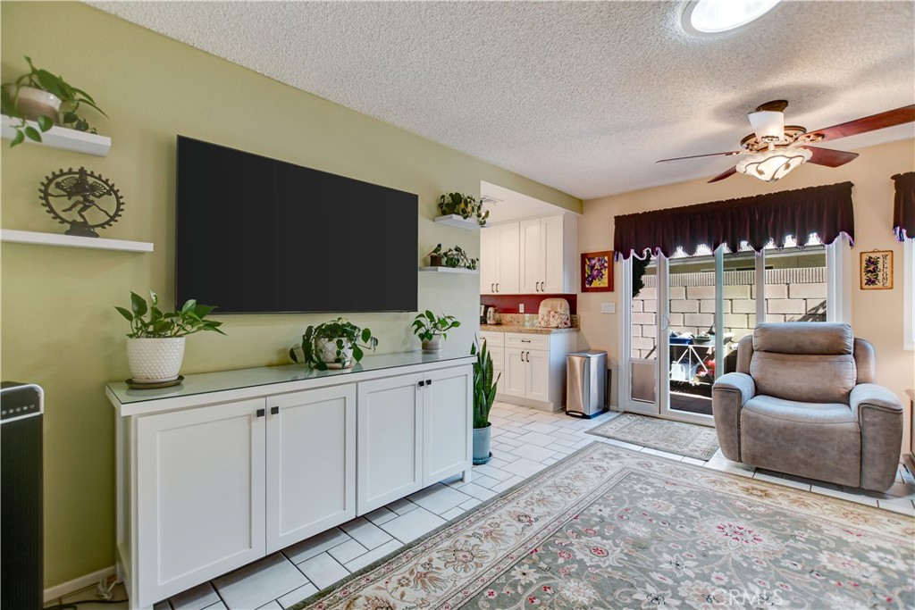 255 Mosport Street Hemet, CA 92544 - Photo 18 of 31 a hall way with furniture a flat screen tv and a potted plant