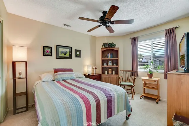 a bedroom with a bed a couch and a ceiling fan