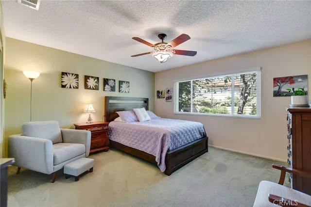a bedroom with a bed couches chair and a window