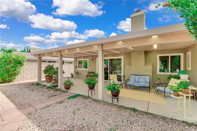 a view of a patio with couches table and chairs and potted plants