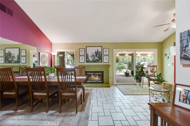 a living room with furniture a fireplace and a floor to ceiling window