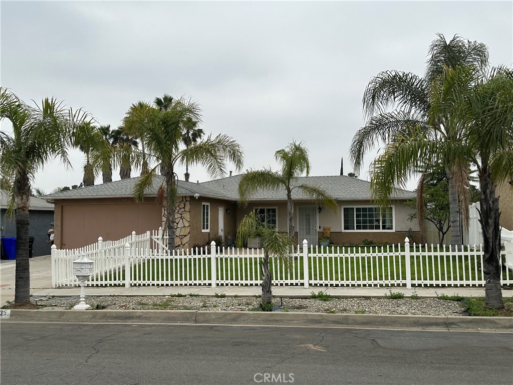a front view of a house with a garden and plants