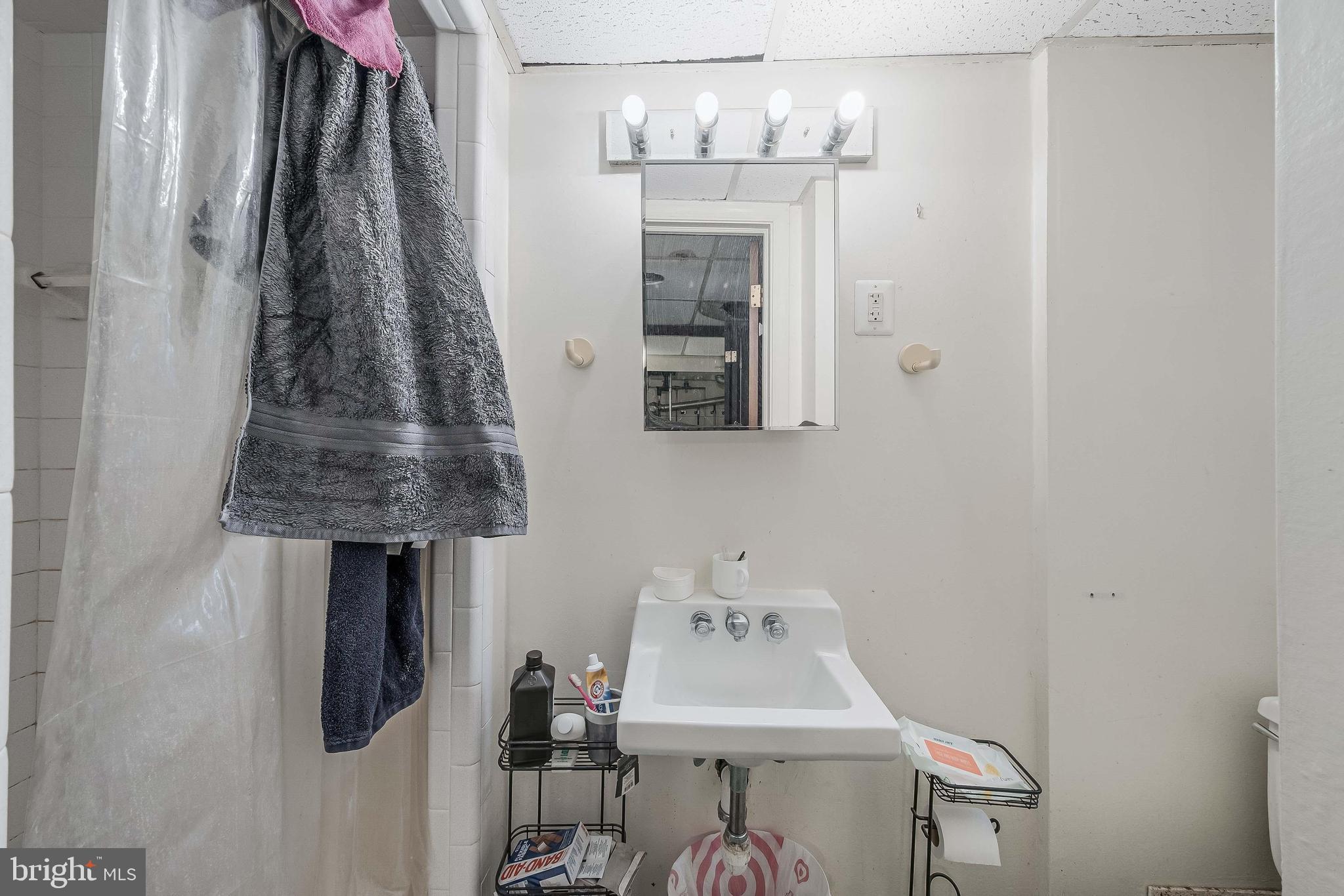 2018 Tunlaw Road Northwest Washington, DC 20007 - Photo 10 of 17 a bathroom with a sink a mirror and shower curtain
