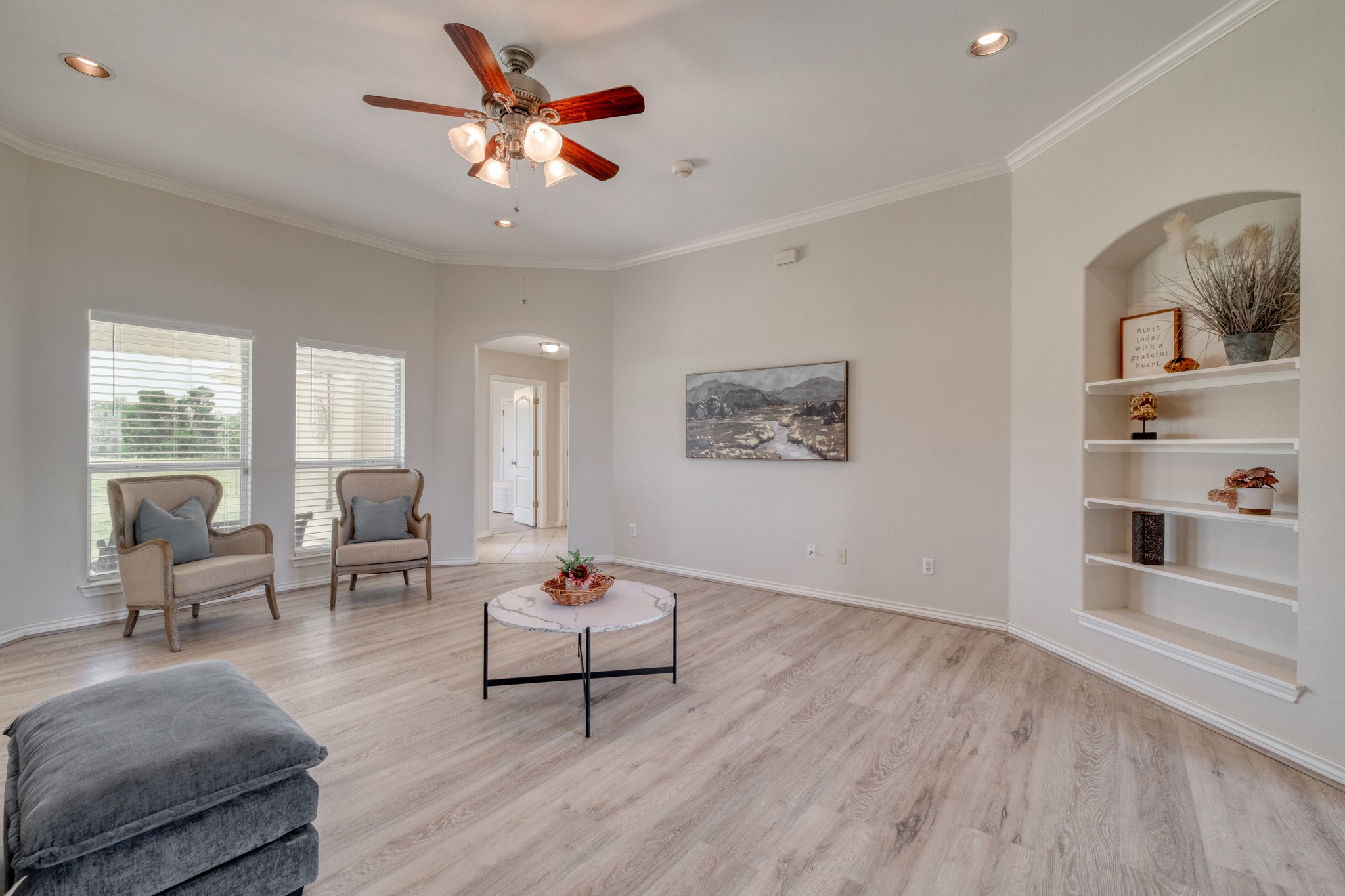 341 Brown Road McDade, TX 78650 - Photo 7 of 38 A spacious living area with wood-look flooring and built-in shelving offers comfortable elegance.