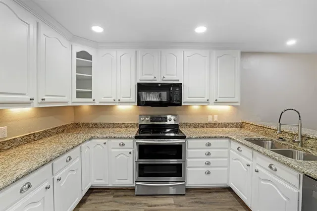 a kitchen with granite countertop a stove and a sink