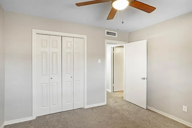 an empty room with fan and windows