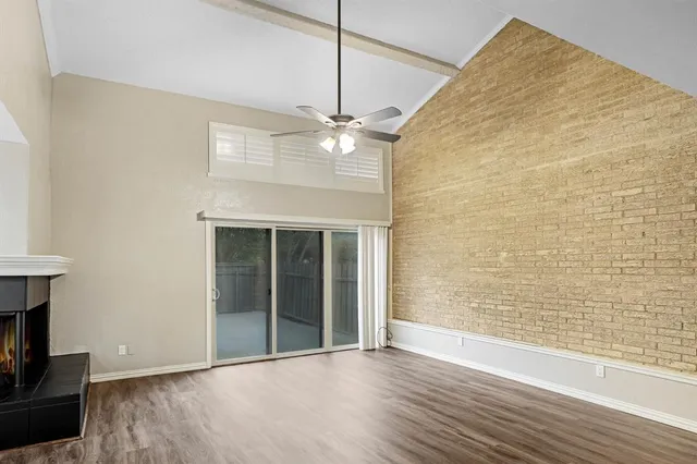 a view of an empty room with a fireplace and a window