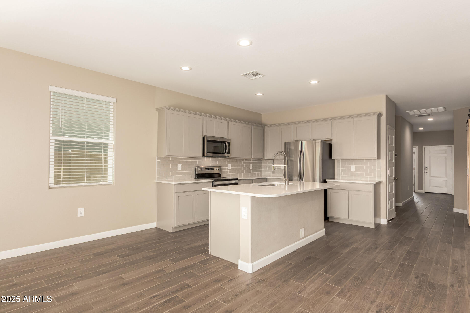1357 East Chillingham Road San Tan Valley, AZ 85143 - Photo 12 of 32 a kitchen with stainless steel appliances a white cabinets and wooden floor
