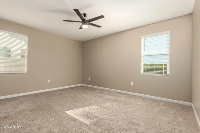 a view of a room with a ceiling fan and entryway