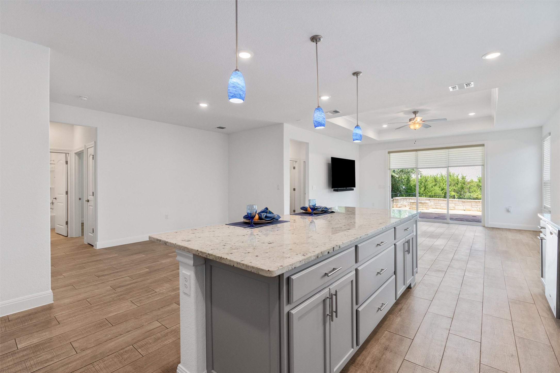 202 Spanish Star Street Georgetown, TX 78633 - Photo 13 of 32 a view of a kitchen with kitchen island a counter top space appliances and a ceiling fan