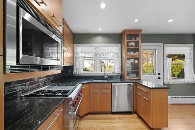 a kitchen with stainless steel appliances granite countertop a stove a sink and a refrigerator