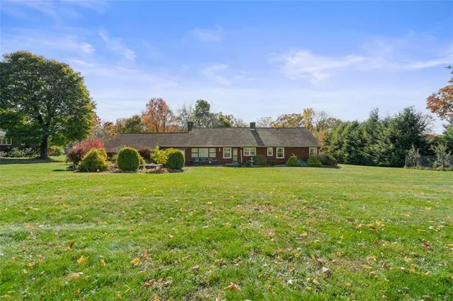 a view of grassy field with house in background