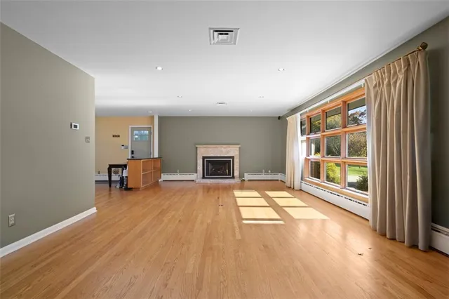 a view of a livingroom with wooden floor and a fireplace