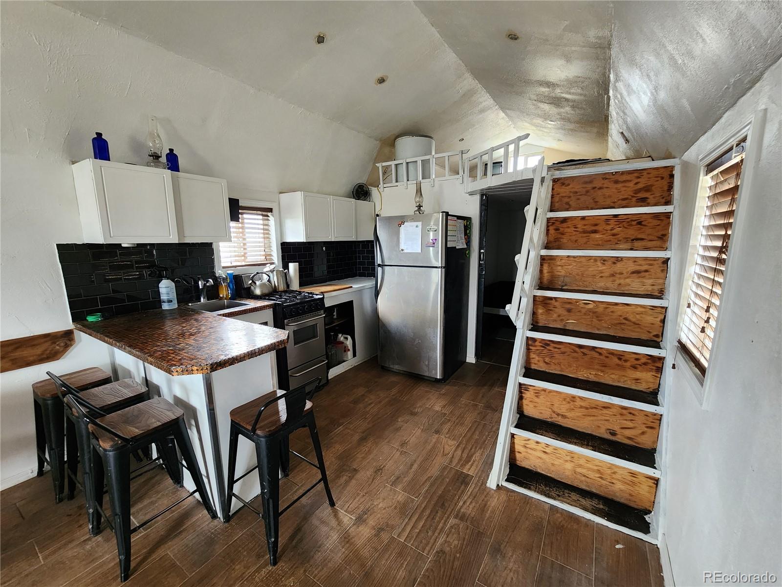 161 Fourmile Creek Road Hartsel, CO 80449 - Photo 19 of 31 a kitchen with stainless steel appliances a stove a refrigerator and wooden cabinets