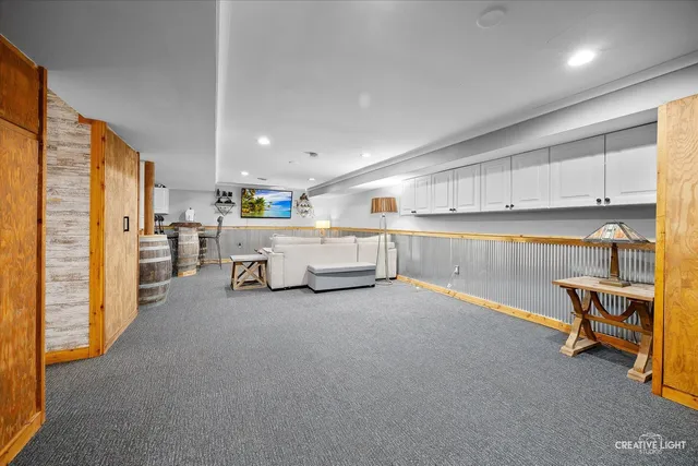 a living room with stainless steel appliances furniture and a kitchen view