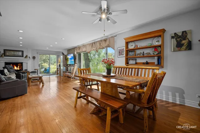 a dining room with furniture a floor to ceiling window and wooden floor