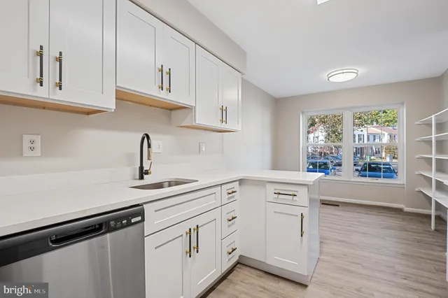 a kitchen with white cabinets and appliances