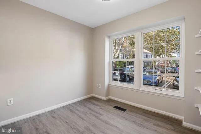 an empty room with wooden floor and window