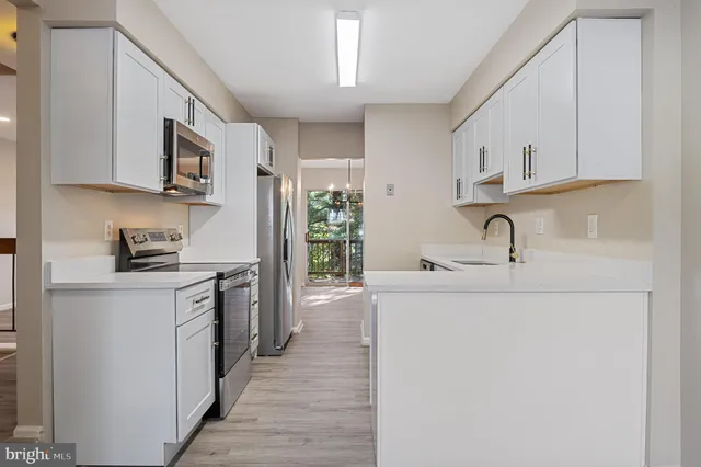 a kitchen with white cabinets and appliances