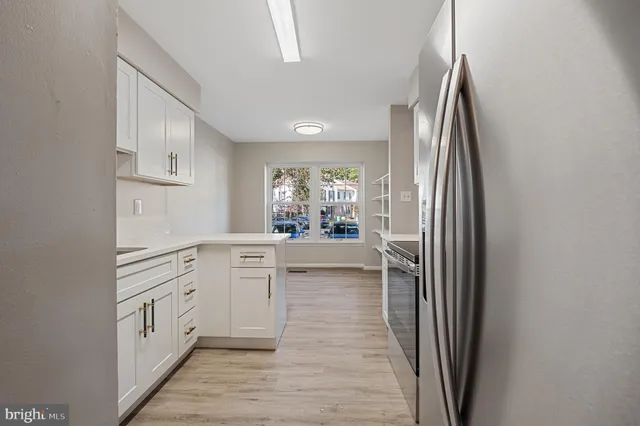 a kitchen with a refrigerator stove and white cabinets