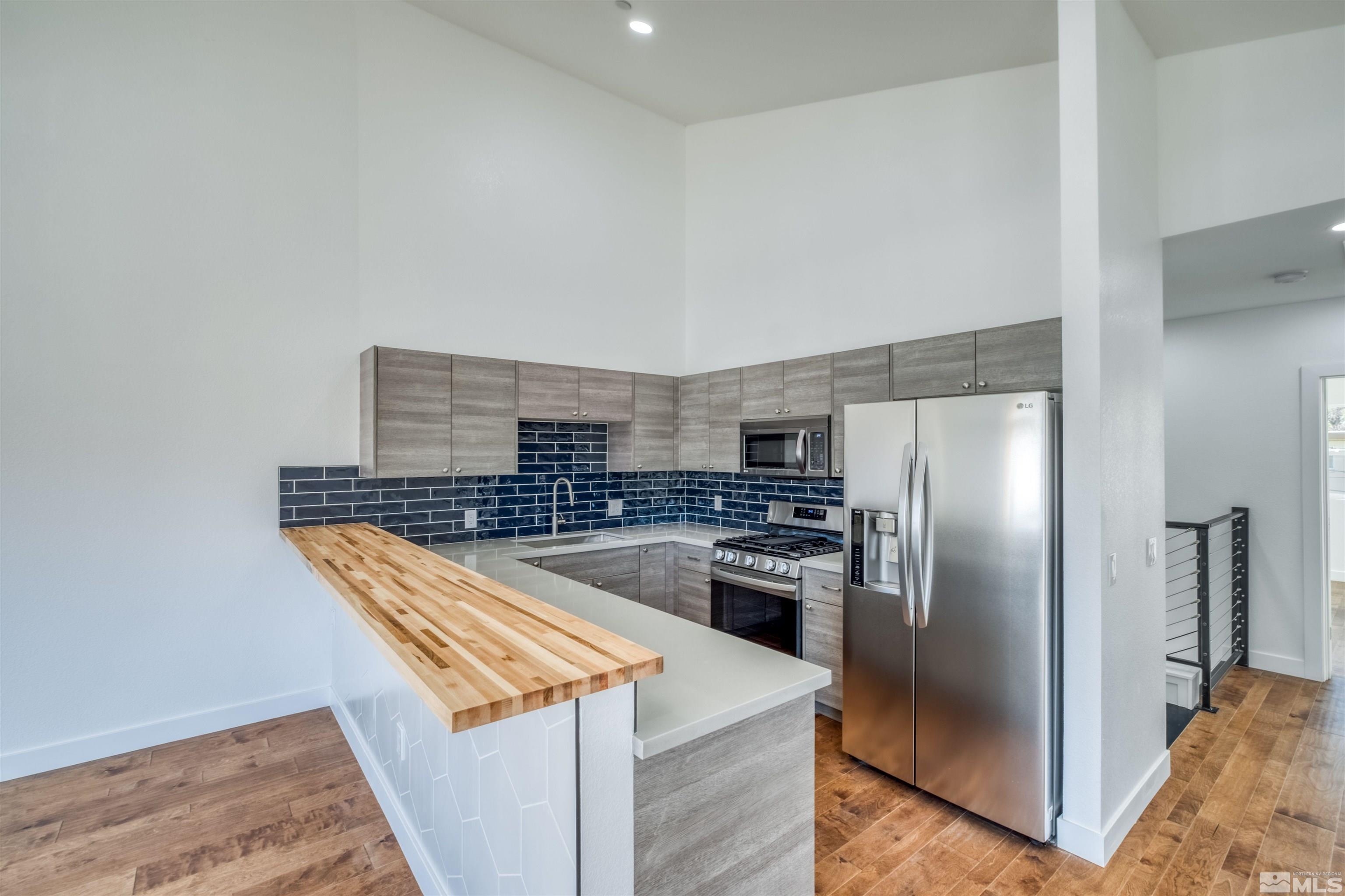 335 Roberts Street Reno, NV 89502 - Photo 10 of 18 a kitchen with stainless steel appliances granite countertop a refrigerator a stove and a sink