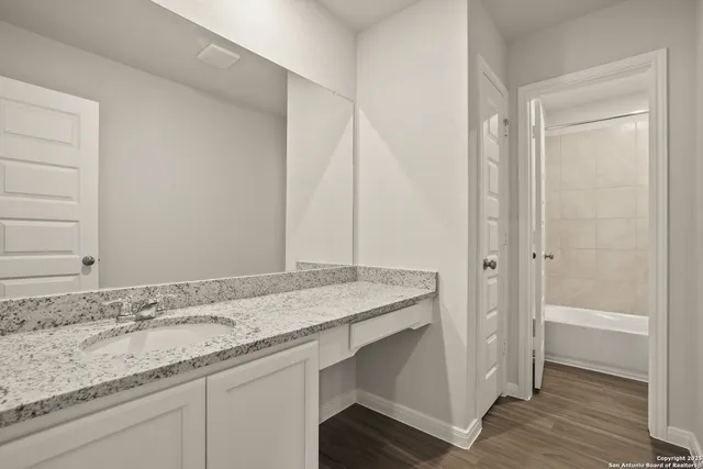 a bathroom with a granite countertop sink and a mirror