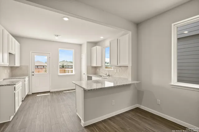 a view of a kitchen with wooden floor and a window