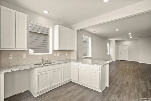 a kitchen with a sink cabinets and wooden floor