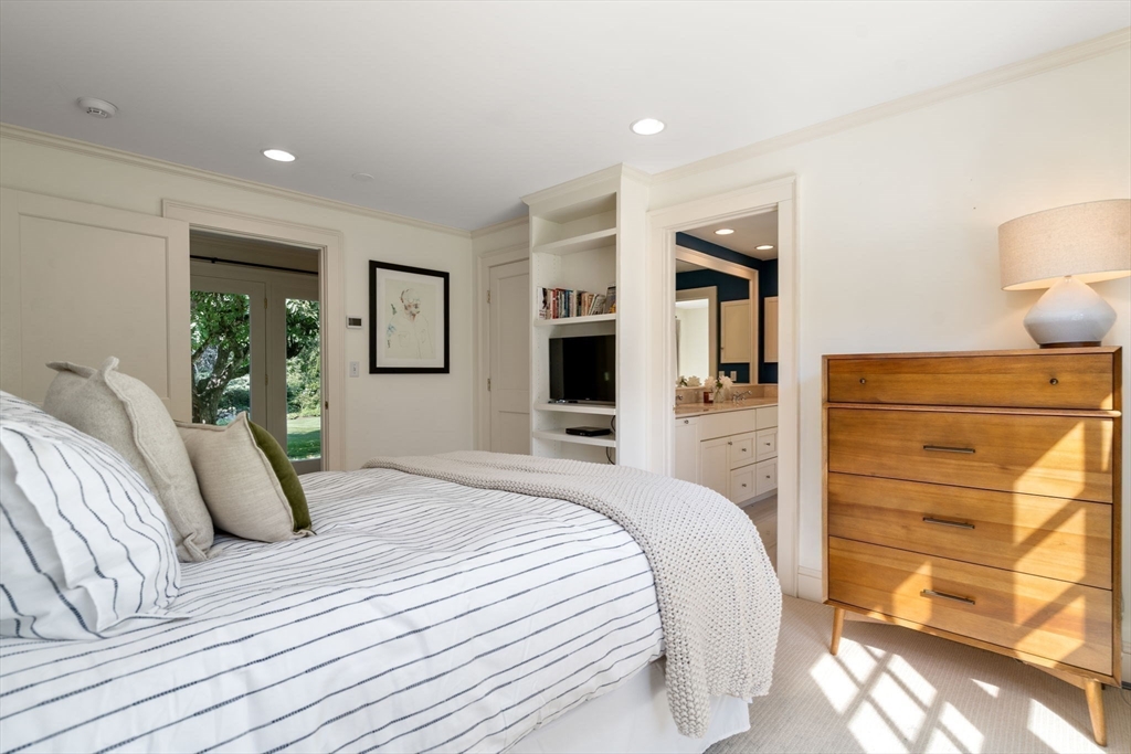339 Pope Road Concord, MA 01742 - Photo 24 of 40 a bedroom with a bed and dresser with mirror