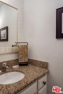 a bathroom with a granite countertop sink and a mirror