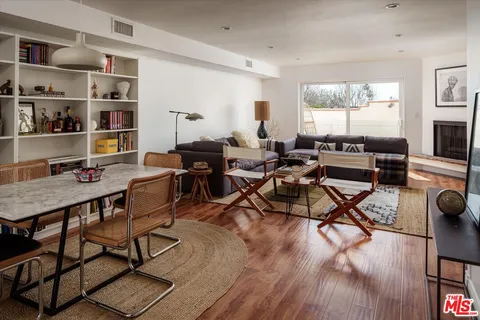 a living room with furniture a flat screen tv and a floor to ceiling window
