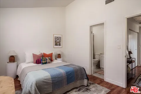 a bedroom with a bed and a painting on the wall