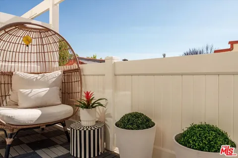 a view of a hallway with wooden floor and a potted plant