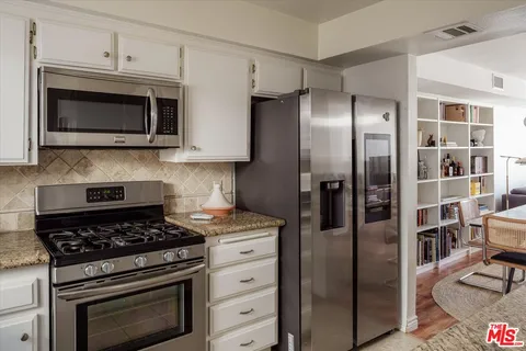 a kitchen with stainless steel appliances granite countertop a stove and a refrigerator