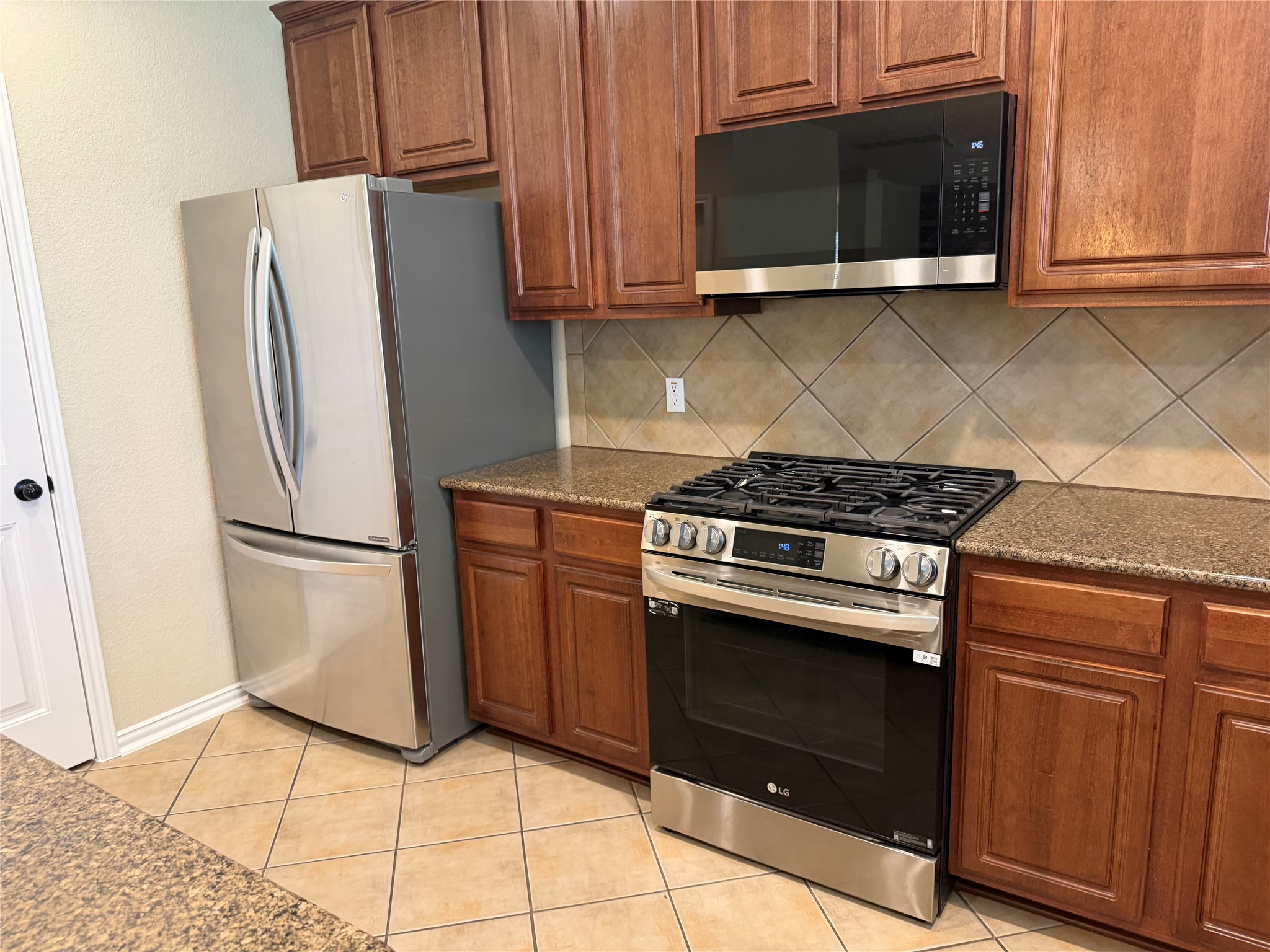 3021 Grand Mission Way Pflugerville, TX 78660 - Photo 14 of 31 The kitchen offers ample storage with rich wooden cabinetry and stone countertops.