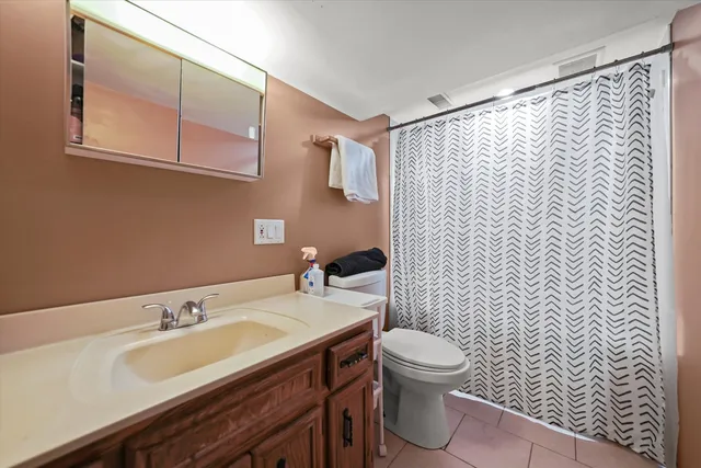 a bathroom with a granite countertop sink a toilet and a mirror
