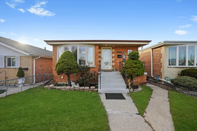 a front view of a house with a garden and plants