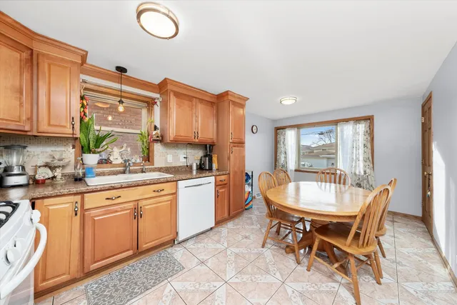 a kitchen with a dining table chairs and white cabinets
