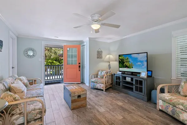 a living room with furniture a flat screen tv and a large window
