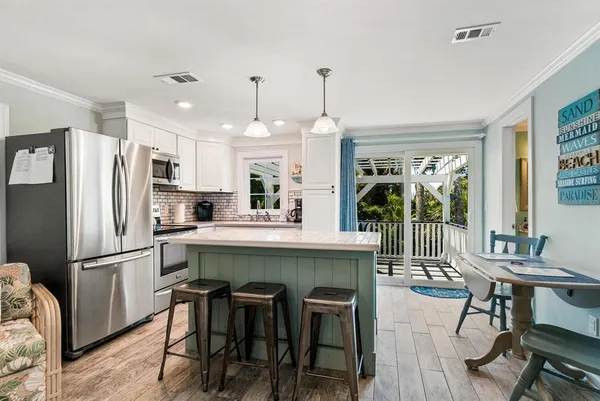 a kitchen with refrigerator cabinets dining table and chairs
