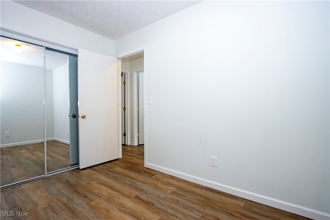2781 North Firestone Road Wooster, OH 44691 - Photo 15 of 41 Unfurnished bedroom featuring hardwood / wood-style floors, a closet, and a textured ceiling