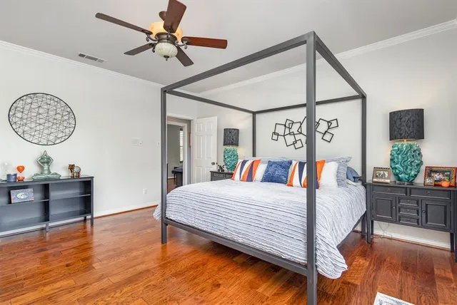 a bedroom with a bed chandelier and a window