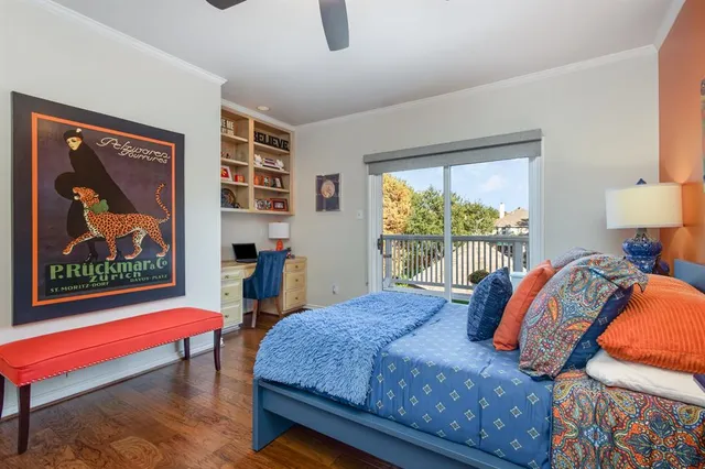 a bedroom with a bed a lamp on wall and a large window