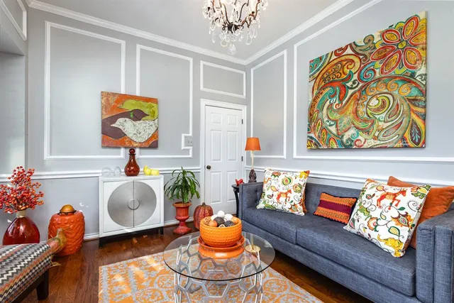 a living room with blue lights with furniture and paintings on the wall