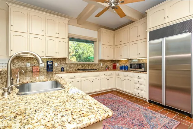 a kitchen with stainless steel appliances granite countertop a refrigerator sink and cabinets