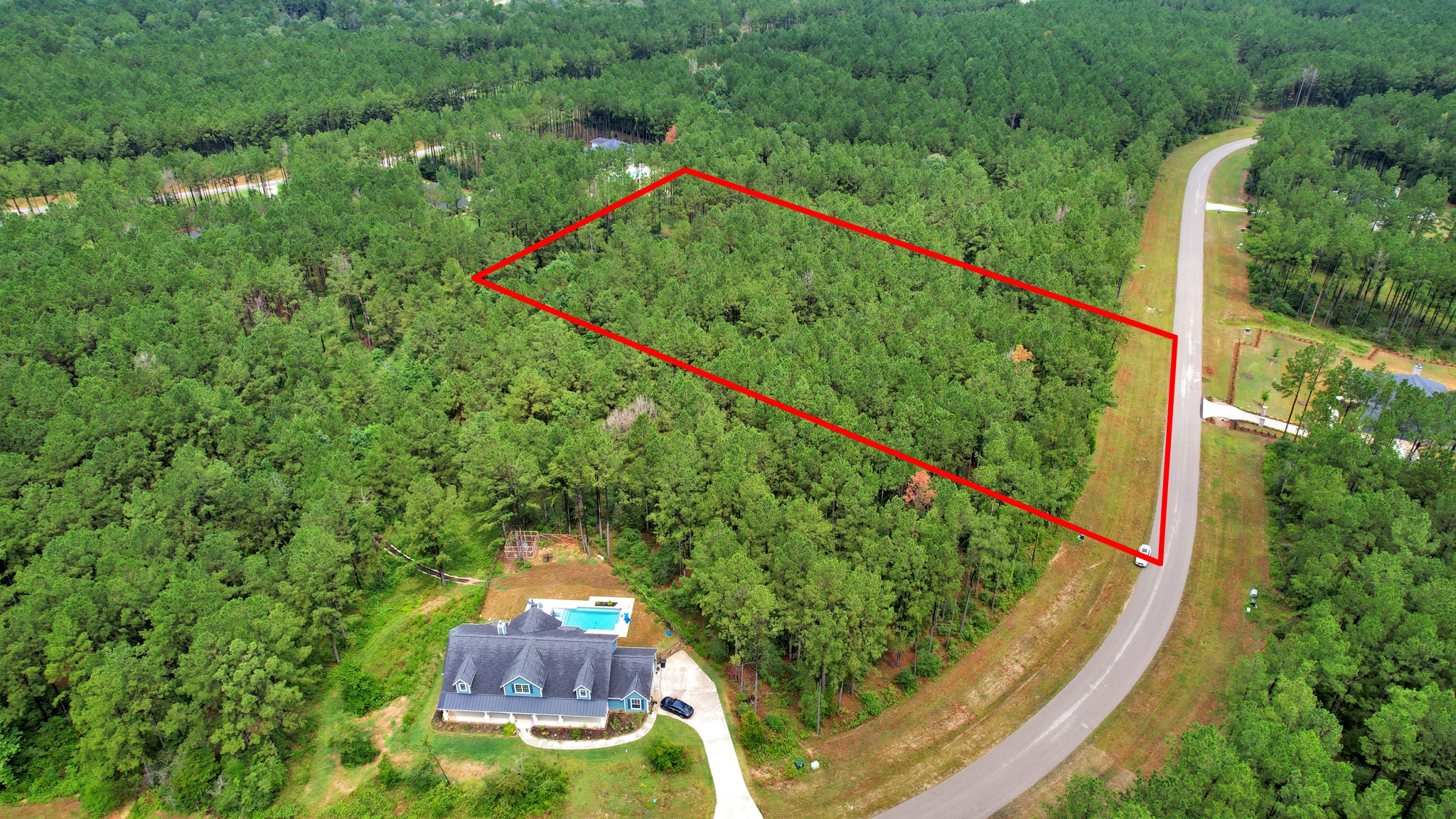 an aerial view of a house with a garden and trees
