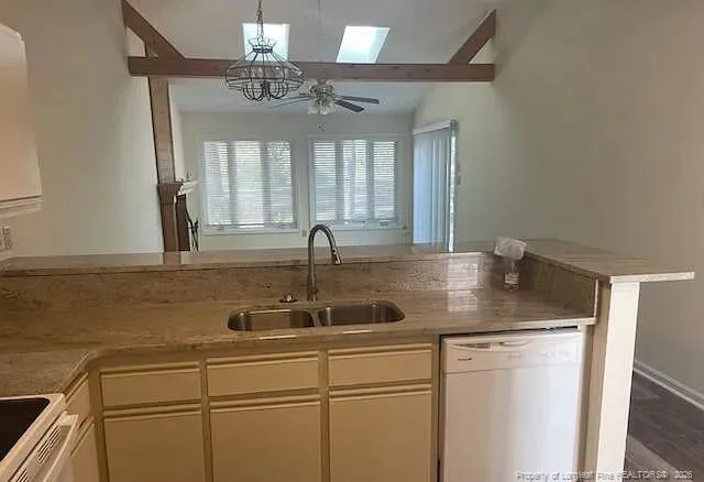 an empty room with a chandelier fan and windows