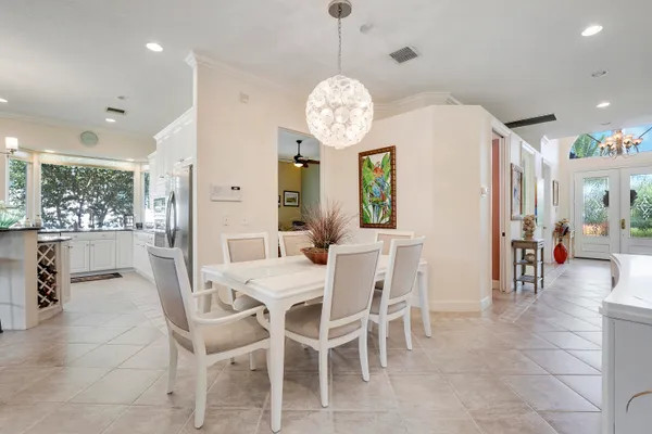 a kitchen with stainless steel appliances granite countertop a table and chairs in it